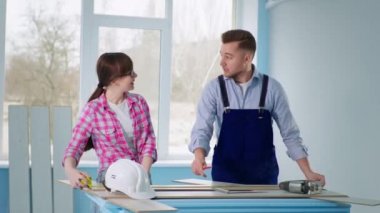 Çiftler yer döşemesini inşaat bandı ve cetvelle ölçüyorlar.