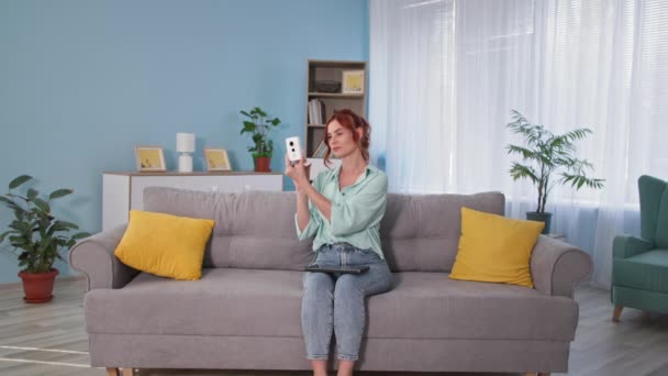 Visual control, girl checks the image quality of hidden video camera using a tablet while sitting on the couch at home — Stock Video