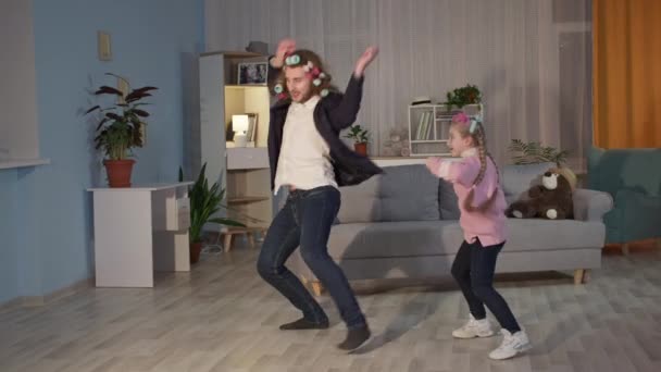 Joyful friendly family father and daughter are jumping and dancing merrily in living room — Stock Video