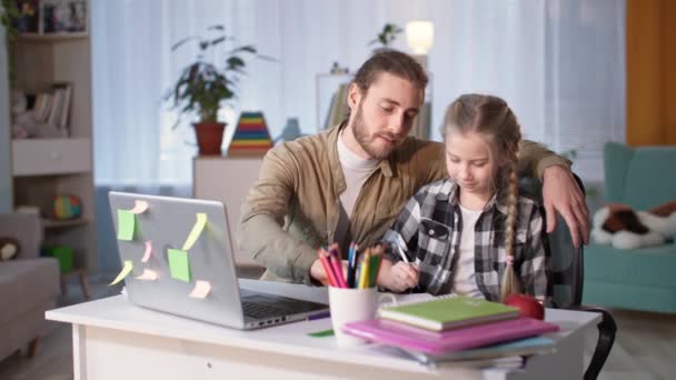 Chica enseñando tareas con su padre en línea con el profesor a través de enlace de vídeo en casa durante la cuarentena — Vídeos de Stock