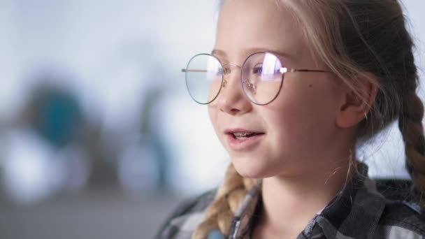 Afstandsles, schoolmeisje geeft les online met leraar via videogesprek op laptop zittend aan tafel thuis — Stockvideo