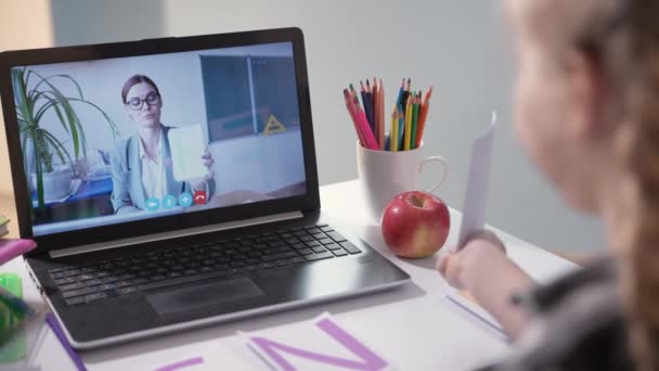 Barn är engagerad med lärare på nätet och undervisar lektioner med hjälp av modern videokommunikationsteknik på bärbar dator — Stockvideo