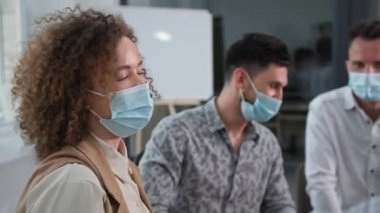 Grup terapisi seansı, tıbbi maske takan mutlu genç bir kadın motivasyon eğitimi sırasında arkadaşlarına başarılarını ve başarılarını anlatıyor.