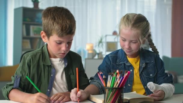 友情2人の小さな友達がスケッチブックにカラフルな鉛筆で絵を描く家で一緒に自由な時間を過ごして — ストック動画