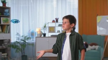 Uçan oyuncakla oynayan sevimli çocuk, portre çocuğu küçük dronu içeri fırlattı ve neşeyle baş parmağını kaldırdı.