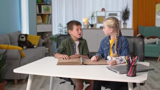 Fuente para discapacitados visuales, niño ciego lectura braille libro con símbolos sentados a la mesa con hermana interior — Vídeos de Stock