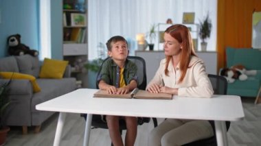 Kör çocuklar için zor bir eğitim, bayan öğretmen görme engelli bir çocuğa masasında sembollerle yazı tipi olan kör alfabesi kitapları okumayı öğretiyor.