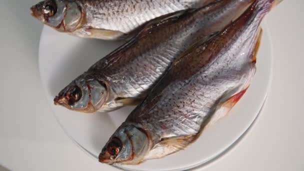 Alimentos saudáveis, peixe salgado suculento em um prato girando em um fundo branco — Vídeo de Stock