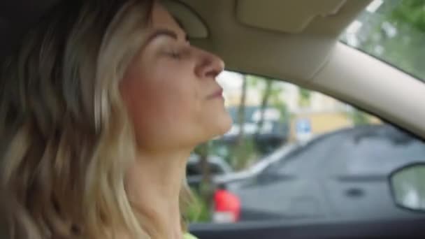 Estilo de vida, hermosa joven conductora se divierte bailando música mientras conduce un coche en la ciudad — Vídeo de stock