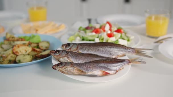 魚介類サラダの近くの皿の上のおいしい新鮮な魚とテーブルの上の揚げジャガイモ、クローズアップ — ストック動画