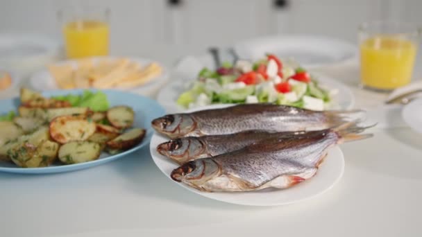 Nutrição adequada, peixe saudável ao lado de salada de legumes e batatas na mesa para um lanche familiar em casa — Vídeo de Stock