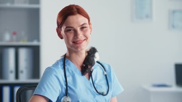 Porträt einer jungen Tierärztin mit süßer Ratte auf den Schultern, die in der Klinik lächelt und in die Kamera blickt — Stockvideo