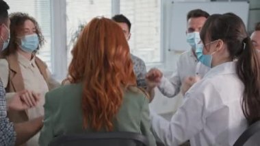 Gençler virüs ve enfeksiyondan korunmak için önlem alıyor ve tıbbi maskeler takıyorlar. Terapi sırasında ellerini çırpıp güven çemberi oluşturuyorlar.