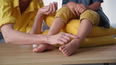 Çocukluğunda, annesi oğluna dizanteri için krem sürmüş, çocuk gülümseyip kameraya bakmış.