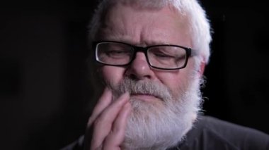 Yaşlı adam derin düşüncelere daldı. Elini nazikçe yüzüne doğru uzatıyor ve parmaklarıyla sakala dokunuyor. Derin düşüncelerini açıkça gösteriyor. Onun keskin, nazik ve özenli bakışları