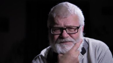 Yaşlı adam derin düşüncelere daldı. Elini nazikçe yüzüne doğru uzatıyor ve parmaklarıyla sakala dokunuyor. Derin düşüncelerini açıkça gösteriyor. Onun keskin, nazik ve özenli bakışları