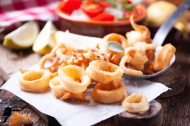 Geleneksel İtalyan kızarmış kalamar ve limon dilimleri.