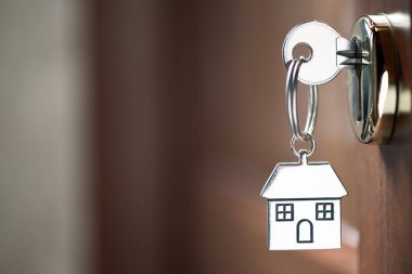 Ev anahtarlığı ahşap kapıdaki anahtar deliğinde. Kapatın.