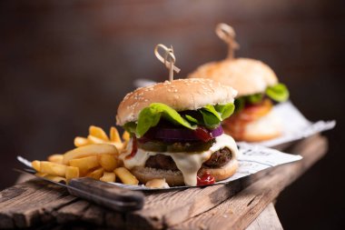 Tahta masada patates kızartması ve ev yapımı hamburger. Kapat.