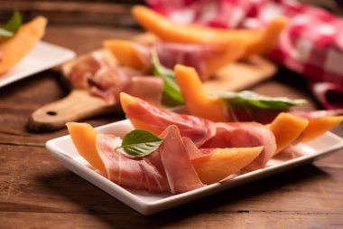 Taze kavun ve beyaz tabakta parma jambonu. Kapat.