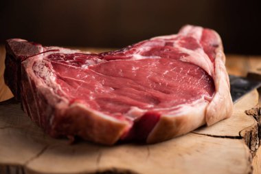 Büyük çiğ fiorentina eti. Tahta bir masanın üstünde. Yakın plan.