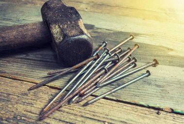 Tahta bir bankta eski çekiç ve çiviler