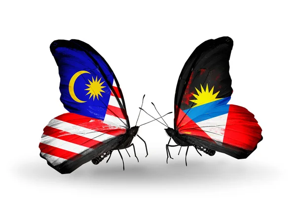 Mariposas con banderas de Malasia y Antigua y Barbuda en alas — Foto de Stock