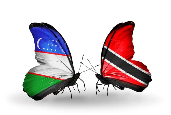 Uzbekistanin sekä Trinidadin ja Tobagon lipun alla purjehtivat perhoset — kuvapankkivalokuva
