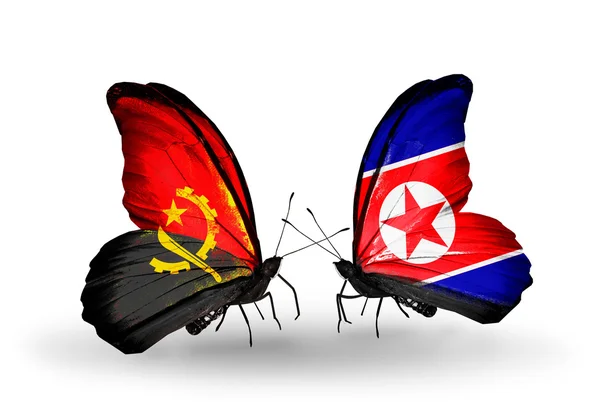 Farfalle con bandiere Angola e Corea del Nord — Foto Stock