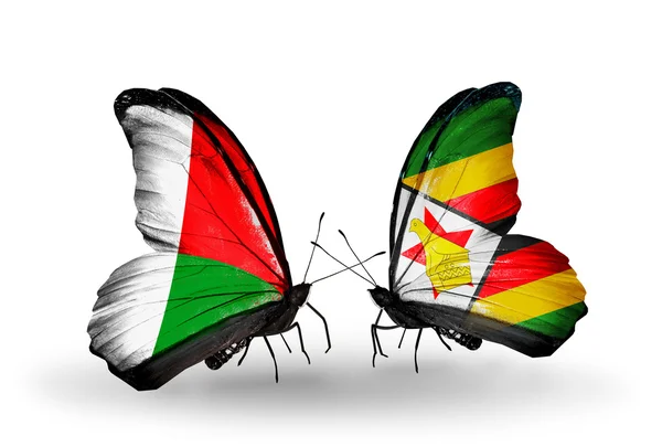 Farfalle con bandiere Madagascar e Zimbabwe — Foto Stock