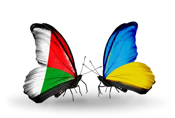Farfalle con bandiere Madagascar e Ucraina — Foto Stock