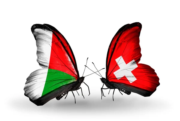 Borboletas com bandeiras de Madagascar e Suíça — Fotografia de Stock