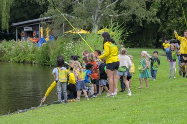 Amsterdamse Bos 'ta bir grup çocuk tarafından yakalanan bir balığı atmak. Hollanda 29-7-2020.