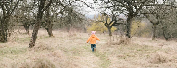 Маленькая девочка бегает в саду — стоковое фото