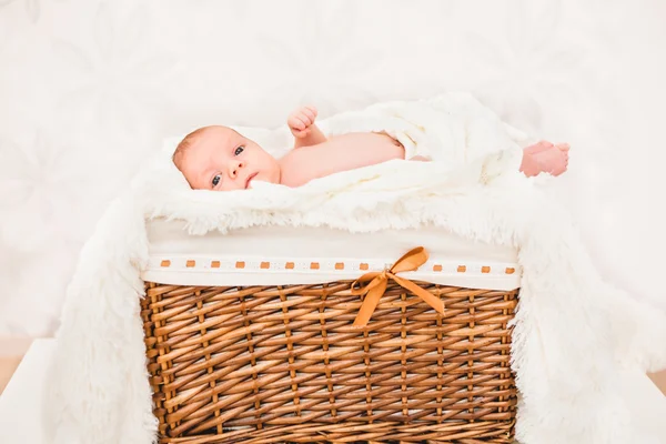 Kleine baby (kind) in een houten mand liggen. pasgeboren — Stockfoto