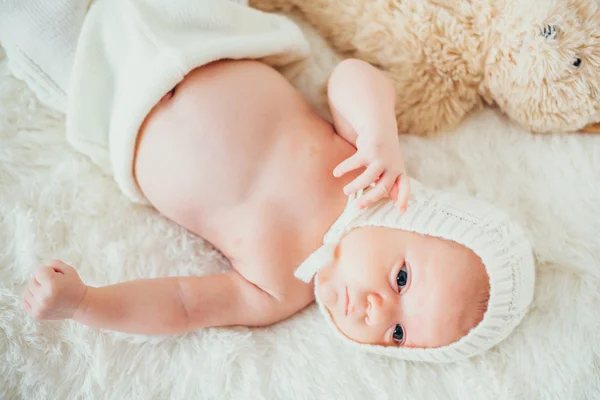 Lite drömsk baby (barn, kid) insvept i en vit stickad tomt — Stockfoto