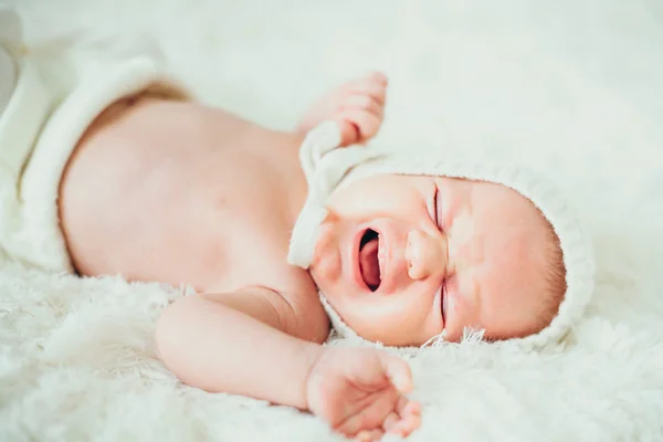 Pequeno bebê (criança) chorar envolto em um branco de malha cobertor newbo — Fotografia de Stock