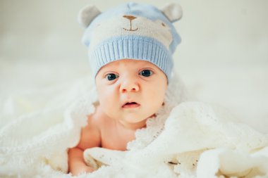 küçük bebek (çocuk) beyaz örgü battaniye içinde yalan. Yeni doğan