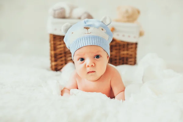 Pequeno bebê (bebê) deitado em um cobertor perto da cesta com areia — Fotografia de Stock