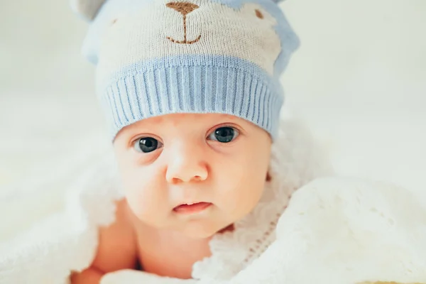 Μικρό παιδί (παιδί) βρίσκεται σε ένα λευκό πλεκτό κάλυμμα. νεογέννητο — Φωτογραφία Αρχείου