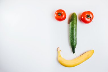 Mutlu yüz taze meyve ile yapılmış. Domates, salatalık, muz.