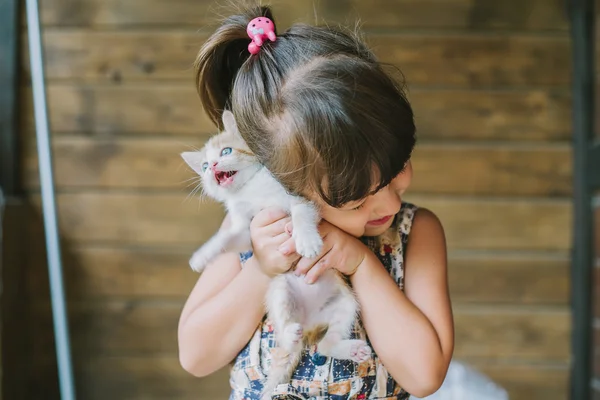 korkmuş kedi elinde tutan neşeli küçük kız