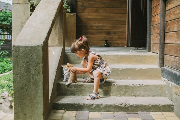 Menina brincando com gatinhos no terraço — Fotografia de Stock