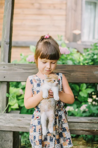 Fille jouer avec chatons sur un banc — Photo