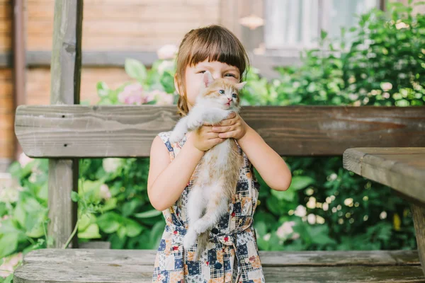 Fille jouer avec chatons sur un banc — Photo