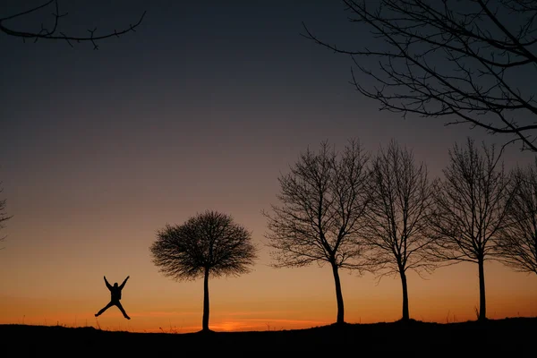 Silhouette di un uomo che salta al tramonto — Foto Stock