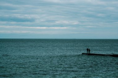 Rıhtımda dikilen çift. Karadeniz. minimalizm.
