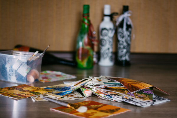 Decoupage napkins lying on the floor .bottles