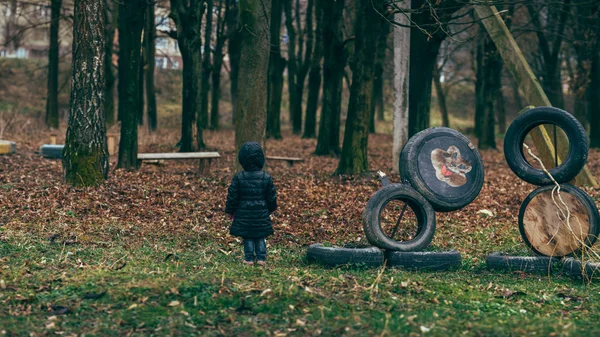 Menina no parque perto do parque infantil — Fotografia de Stock