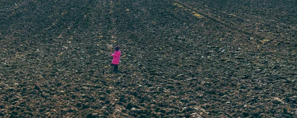 Chica de pie en medio de campos arados — Foto de Stock